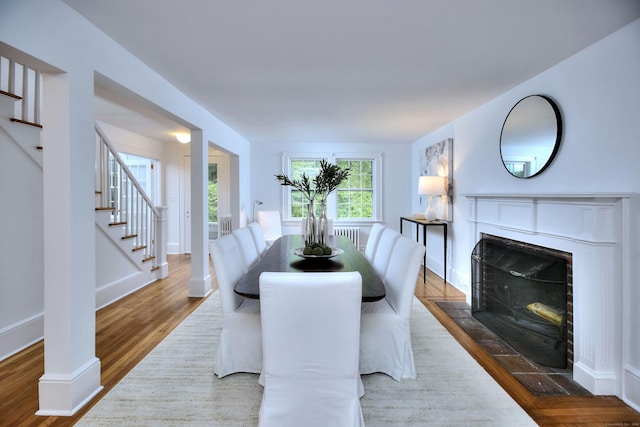 481 Ridgefield Rd, Wilton, CT 06897 - dining room featuring stairway, wood finished floors, a fireplace with flush hearth, baseboards, and radiator