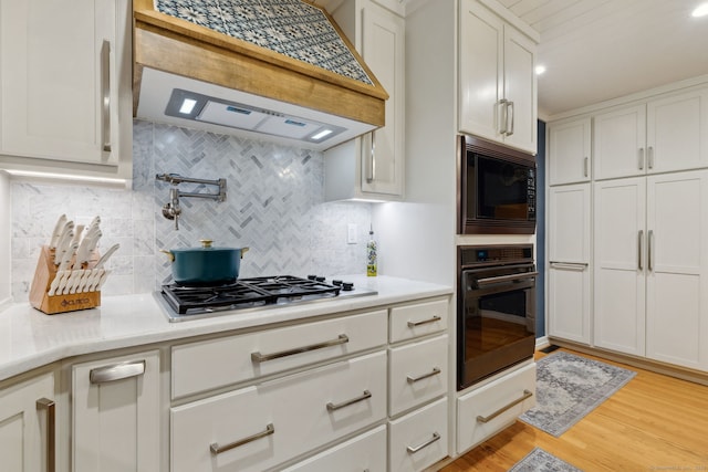 23 Blackhaw Dr, Cromwell, CT 06416 - kitchen with black appliances, under cabinet range hood, white cabinetry, and light countertops