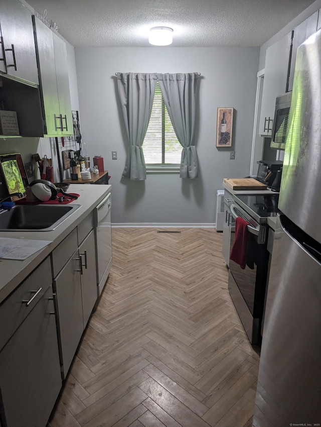 151 Heritage Vlg Unit B, Southbury, CT 06488 - kitchen featuring appliances with stainless steel finishes, a sink, light countertops, baseboards, and a textured ceiling