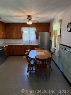 153 Barton St, Torrington, CT 06790 - kitchen featuring freestanding refrigerator, a sink, a ceiling fan, brown cabinets, and range