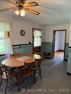 153 Barton St, Torrington, CT 06790 - dining area with healthy amount of natural light, a wainscoted wall, a ceiling fan, and tile patterned floors