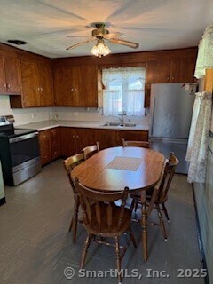 153 Barton St, Torrington, CT 06790 - kitchen featuring freestanding refrigerator, stainless steel electric stove, brown cabinetry, a ceiling fan, and light countertops