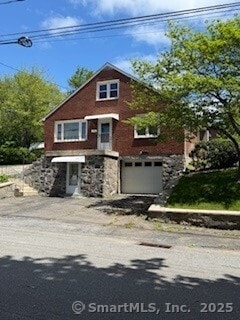 153 Barton St, Torrington, CT 06790 - view of front of house featuring stone siding, an attached garage, and driveway