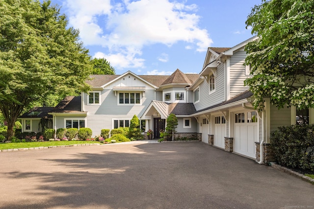 166 Long Lots Rd, Westport, CT 06880 - view of front of home featuring asphalt driveway, a garage, board and batten siding, stone siding, and a shingled roof