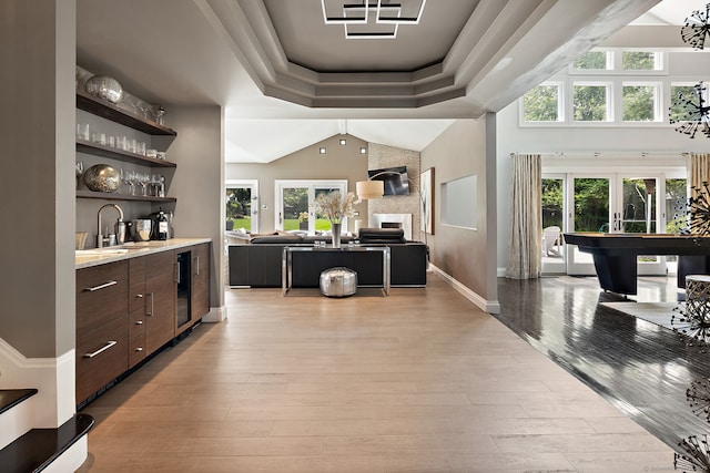 166 Long Lots Rd, Westport, CT 06880 - indoor wet bar featuring light wood-style floors, wine cooler, french doors, lofted ceiling, and a tray ceiling