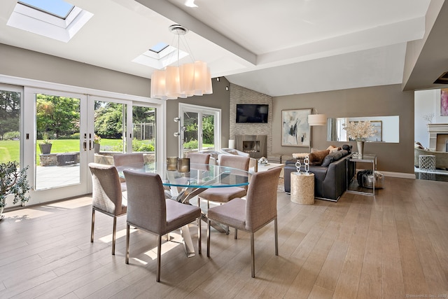 166 Long Lots Rd, Westport, CT 06880 - dining space with a large fireplace, a skylight, french doors, and light wood finished floors