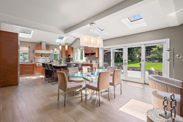 166 Long Lots Rd, Westport, CT 06880 - dining space with a skylight, light wood-style floors, and french doors