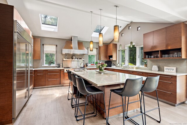 166 Long Lots Rd, Westport, CT 06880 - kitchen featuring wall chimney range hood, appliances with stainless steel finishes, a skylight, open shelves, and decorative backsplash