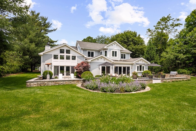 166 Long Lots Rd, Westport, CT 06880 - rear view of house with a patio area, a chimney, and a lawn