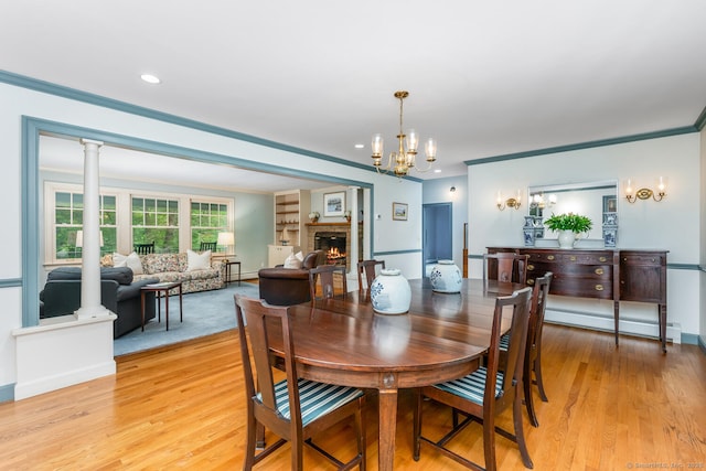66 Saunders Dr, Wilton, CT 06897 - dining room with a baseboard heating unit, crown molding, light wood-style floors, a chandelier, and a lit fireplace