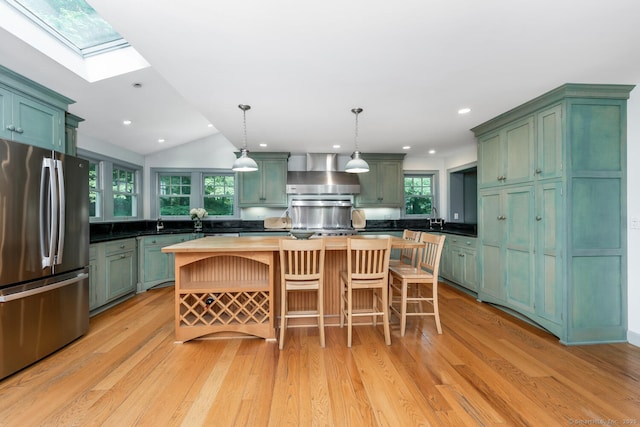 66 Saunders Dr, Wilton, CT 06897 - kitchen featuring freestanding refrigerator, wall chimney exhaust hood, green cabinets, light wood finished floors, and a center island