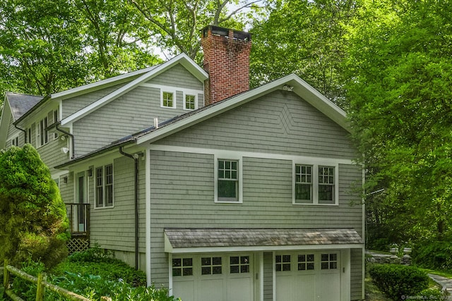 66 Saunders Dr, Wilton, CT 06897 - view of side of home featuring a chimney and an attached garage
