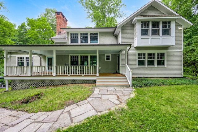 66 Saunders Dr, Wilton, CT 06897 - view of front of house with a front lawn, covered porch, and a chimney