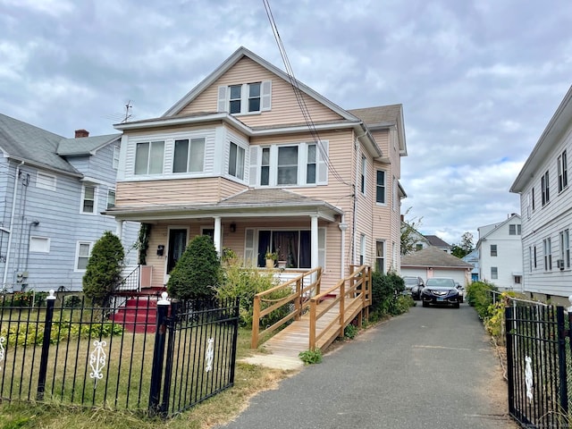 190 Holcomb St, Hartford, CT 06112 - view of front facade with covered porch, a fenced front yard, a detached garage, and an outdoor structure