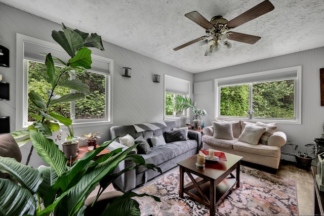 314 Old Wolcott Rd, Bristol, CT 06010 - living area featuring ceiling fan, a textured ceiling, wood finished floors, and wood walls
