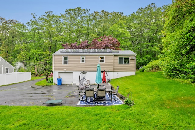314 Old Wolcott Rd, Bristol, CT 06010 - rear view of property featuring driveway, a yard, an attached garage, and a patio