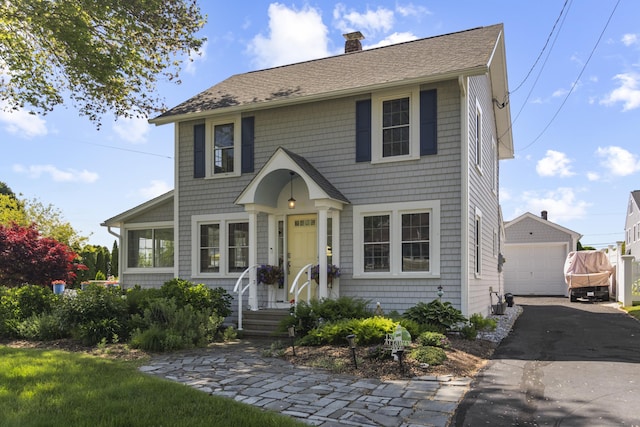 15 Attawan Ave, East Lyme, CT 06357 - view of front of property featuring an outbuilding, asphalt driveway, a chimney, a garage, and a shingled roof