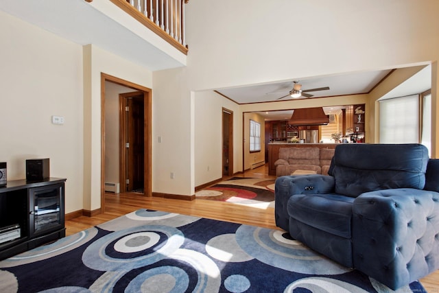 10 Colonial Dr, Clinton, CT 06413 - living room featuring light wood-style floors, a baseboard heating unit, healthy amount of natural light, baseboards, and a towering ceiling