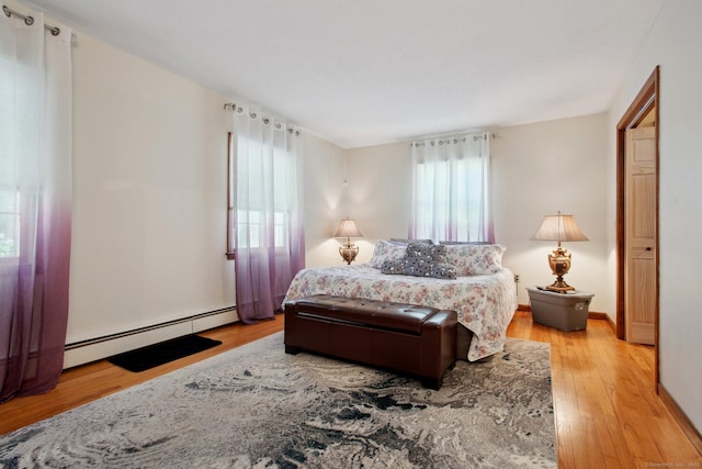 10 Colonial Dr, Clinton, CT 06413 - bedroom featuring baseboard heating, light wood finished floors, and baseboards