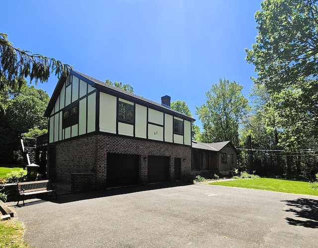 37 Judy Ln, Wolcott, CT 06716 - tudor home with a garage, brick siding, asphalt driveway, a chimney, and a front yard