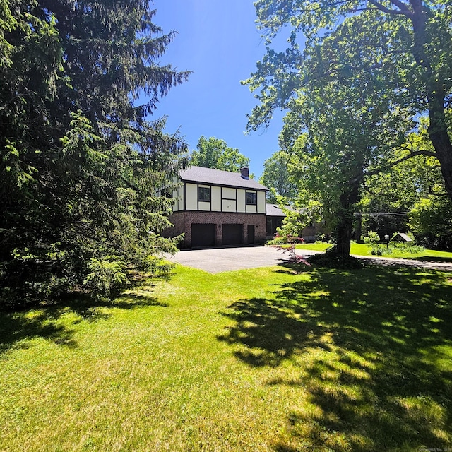 37 Judy Ln, Wolcott, CT 06716 - view of green lawn featuring a garage and asphalt driveway