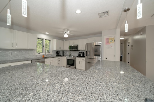56 Buena Vista Dr, East Hartford, CT 06118 - kitchen with stainless steel appliances, a ceiling fan, a sink, tasteful backsplash, and white cabinets