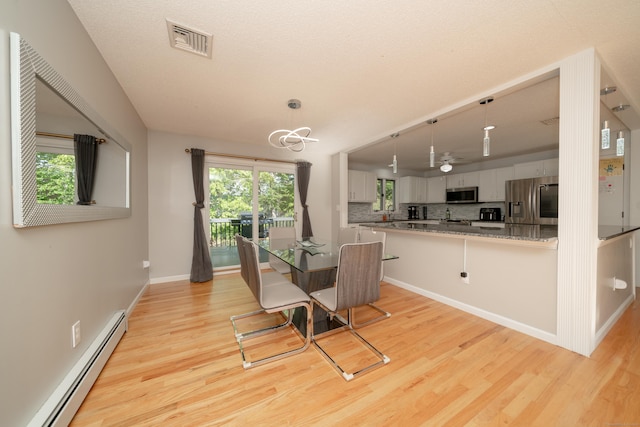 56 Buena Vista Dr, East Hartford, CT 06118 - dining area featuring baseboard heating, light wood-type flooring, baseboards, and a chandelier