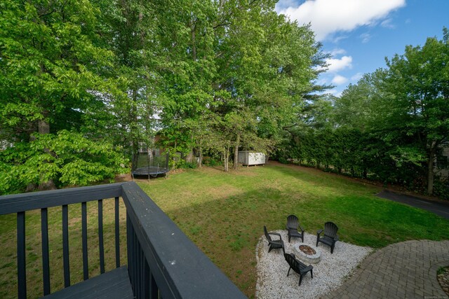 56 Buena Vista Dr, East Hartford, CT 06118 - view of grassy yard featuring a trampoline and an outdoor fire pit