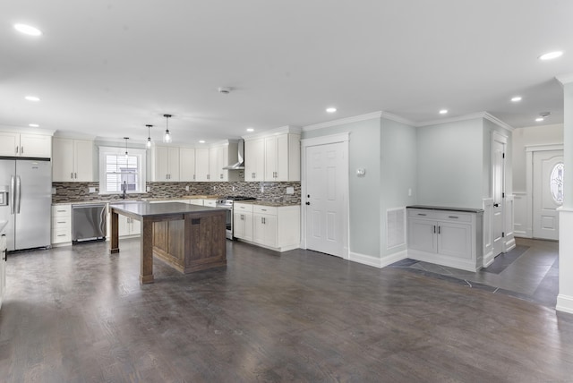 864 Baldwin St, Waterbury, CT 06706 - kitchen with appliances with stainless steel finishes, wall chimney exhaust hood, decorative backsplash, ornamental molding, and recessed lighting