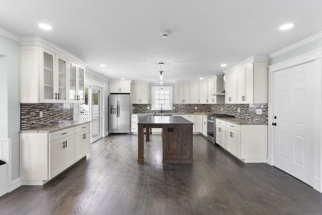 864 Baldwin St, Waterbury, CT 06706 - kitchen with appliances with stainless steel finishes, a sink, dark wood-type flooring, white cabinets, and ornamental molding