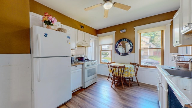 174 Fairview Ave, Bridgeport, CT 06606 - kitchen with white appliances, under cabinet range hood, light wood-style floors, and white cabinets