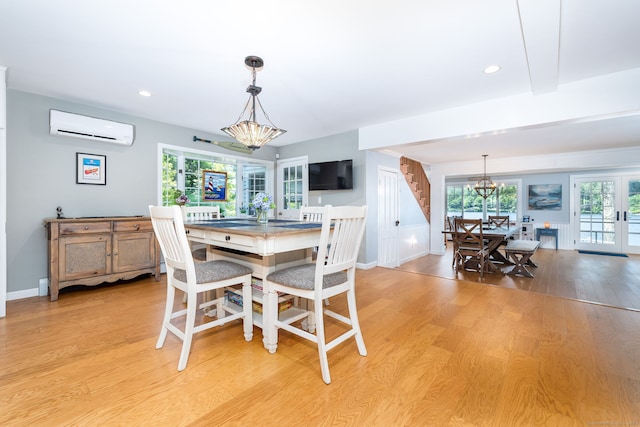 424 E Wakefield Blvd, Winchester, CT 06098 - dining space featuring a wall unit AC, a chandelier, stairs, light wood-style flooring, and baseboards