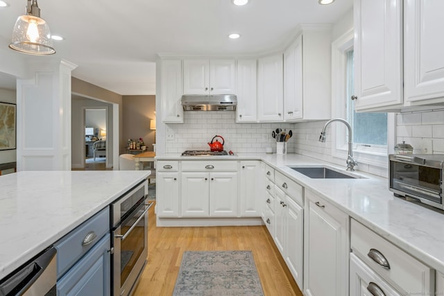 6 Queens Ln, Darien, CT 06820 - kitchen with stainless steel appliances, a sink, under cabinet range hood, white cabinetry, and recessed lighting