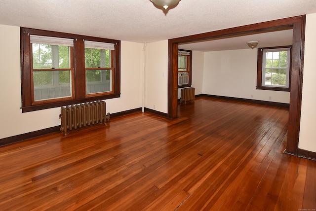 17 Spruce St, Vernon, CT 06066 - empty room featuring radiator, baseboards, hardwood / wood-style floors, healthy amount of natural light, and a textured ceiling