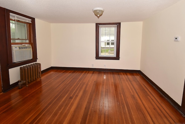 17 Spruce St, Vernon, CT 06066 - unfurnished room with radiator heating unit, wood-type flooring, baseboards, cooling unit, and a textured ceiling