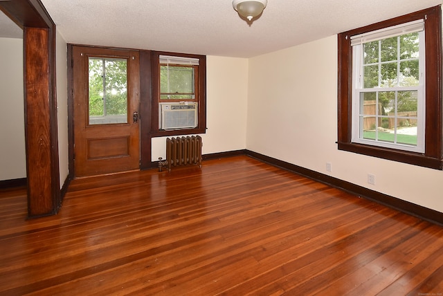 17 Spruce St, Vernon, CT 06066 - unfurnished room featuring radiator heating unit, dark wood-type flooring, baseboards, and a textured ceiling