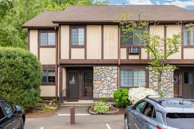202 Foxwood Ln Unit 202, Milford, CT 06461 - view of front of house featuring stucco siding, stone siding, a shingled roof, and uncovered parking