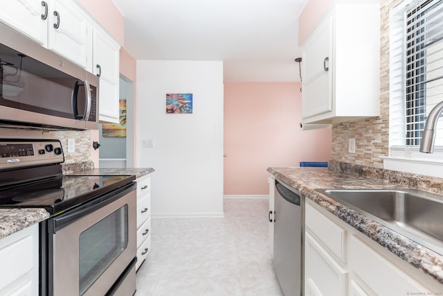 202 Foxwood Ln Unit 202, Milford, CT 06461 - kitchen featuring appliances with stainless steel finishes, a sink, tasteful backsplash, white cabinets, and baseboards