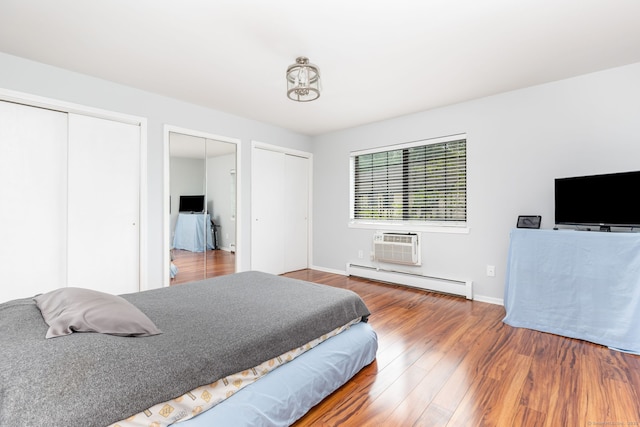 202 Foxwood Ln Unit 202, Milford, CT 06461 - bedroom with a baseboard heating unit, two closets, wood finished floors, baseboards, and an AC wall unit