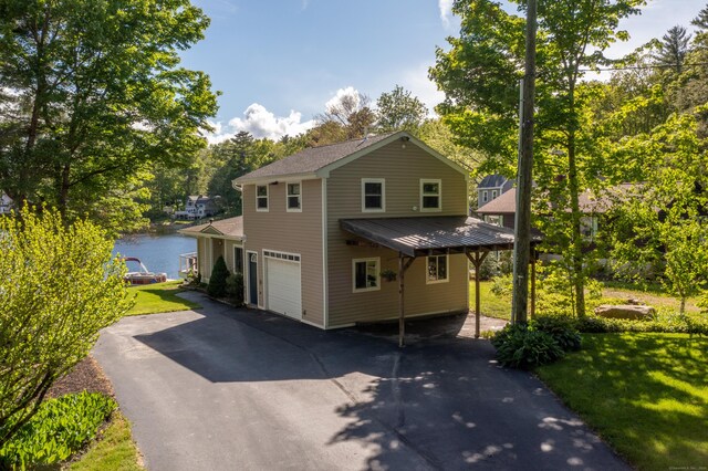 72 Lake View Dr, Woodstock, CT 06281 - view of front of home with asphalt driveway, a garage, a water view, a front yard, and view of scattered trees