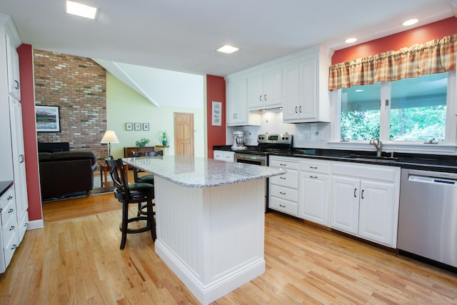 41 Blue Ridge Dr, Simsbury, CT 06089 - kitchen with appliances with stainless steel finishes, light wood-style floors, white cabinets, vaulted ceiling, and recessed lighting