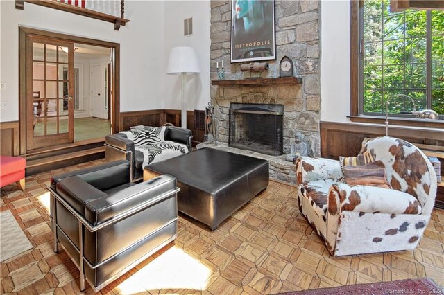15 Tunxis Trl, Redding, CT 06896 - living room featuring a wainscoted wall, a stone fireplace, and wooden walls