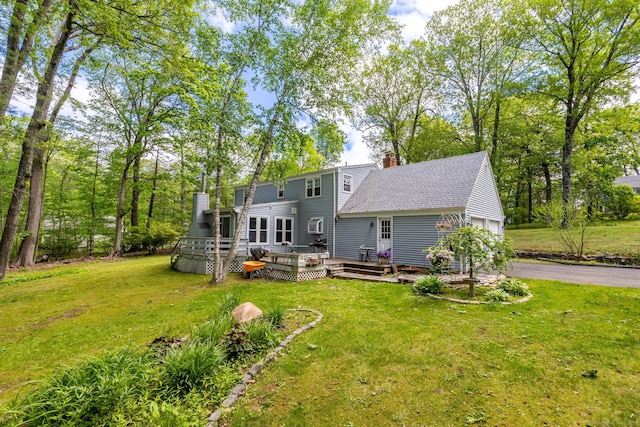 15 Woodcliff Dr, Simsbury, CT 06070 - back of house featuring a chimney, a yard, driveway, and a garage