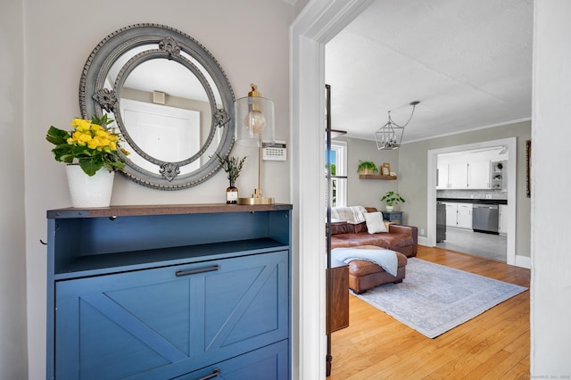 70 Mercer St, Stratford, CT 06614 - hall featuring light wood-style flooring, a chandelier, and ornamental molding