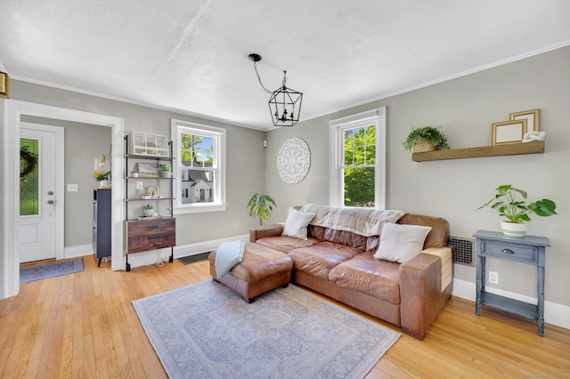 70 Mercer St, Stratford, CT 06614 - living room with light wood-style floors, baseboards, a textured ceiling, ornamental molding, and a chandelier