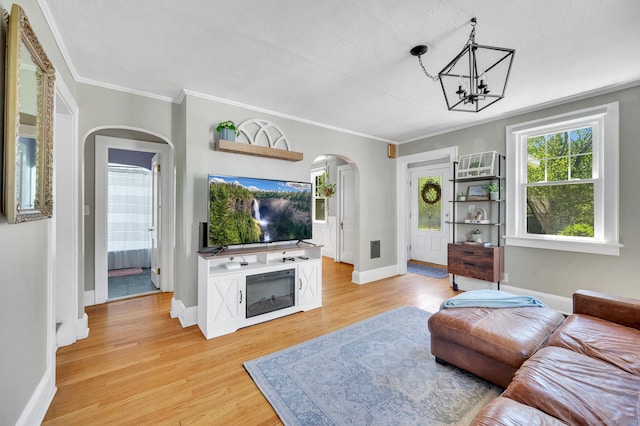 70 Mercer St, Stratford, CT 06614 - living area with arched walkways, light wood-type flooring, a chandelier, baseboards, and crown molding