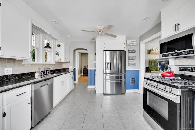 70 Mercer St, Stratford, CT 06614 - kitchen featuring stainless steel appliances, open shelves, a ceiling fan, arched walkways, and tasteful backsplash