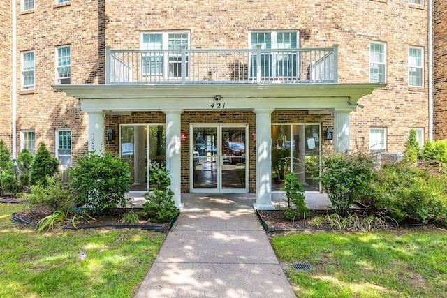 421 Tolland St Unit 312, East Hartford, CT 06108 - property entrance with a balcony, brick siding, and french doors