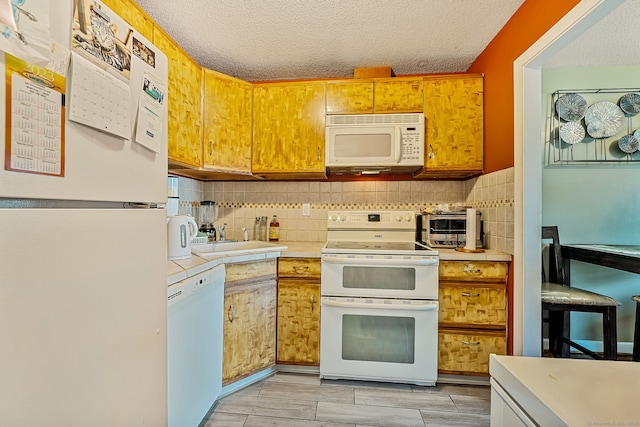 421 Tolland St Unit 312, East Hartford, CT 06108 - kitchen featuring white appliances, decorative backsplash, a textured ceiling, and tile countertops