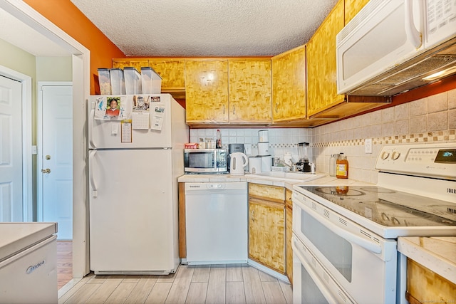 421 Tolland St Unit 312, East Hartford, CT 06108 - kitchen with white appliances, tasteful backsplash, light wood-type flooring, a textured ceiling, and tile counters